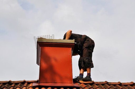 Chimney cleaning service from Attica Air Duct Cleaning, shows a technician doing a sweep on the chimney.