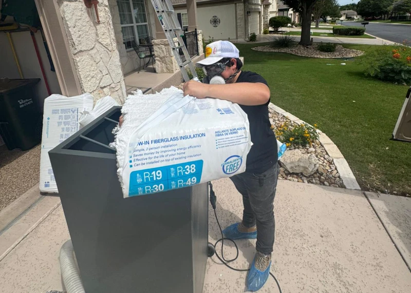 Attic insulation professional removing blow-in fibreglass outer packaging