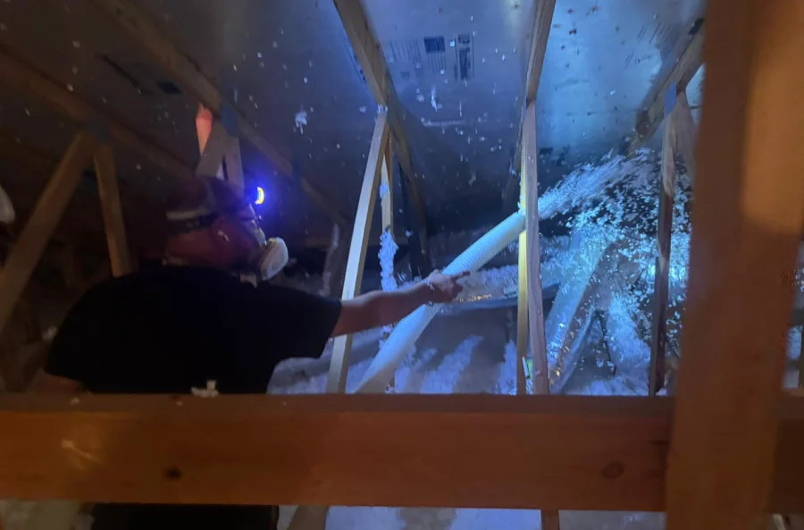 Attica technician installing attic insulation